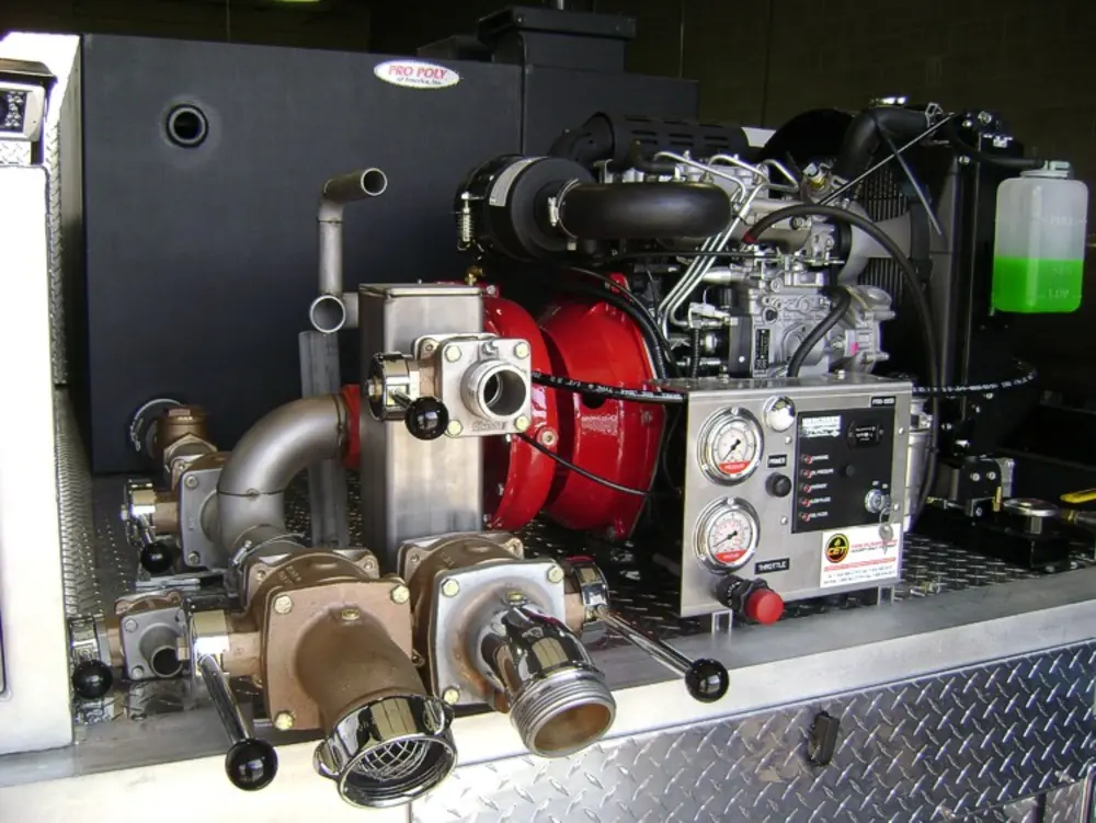 Exterior view of small fire truck showing cab, body compartments, and wheel/tire area.