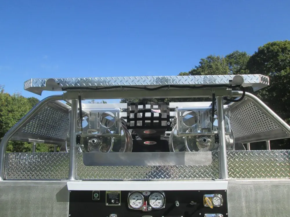 Exterior view of small fire truck showing cab, body compartments, and wheel/tire area.
