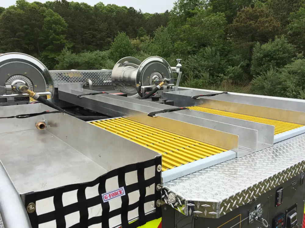 Exterior view of small fire truck showing cab, body compartments, and wheel/tire area.