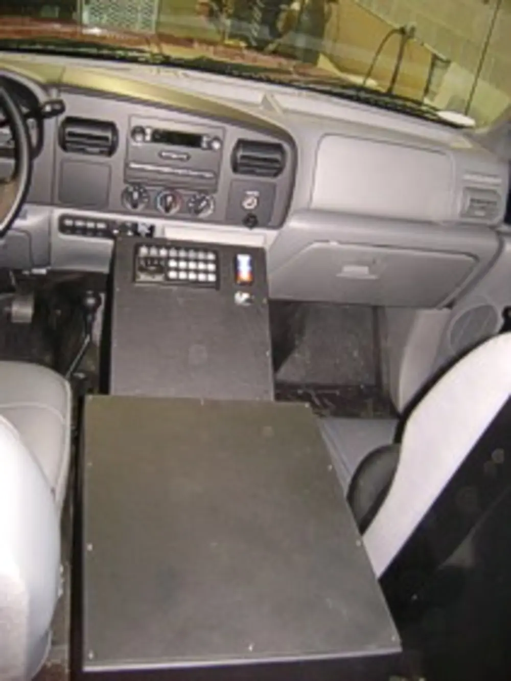 Exterior view of small fire truck showing cab, body compartments, and wheel/tire area.