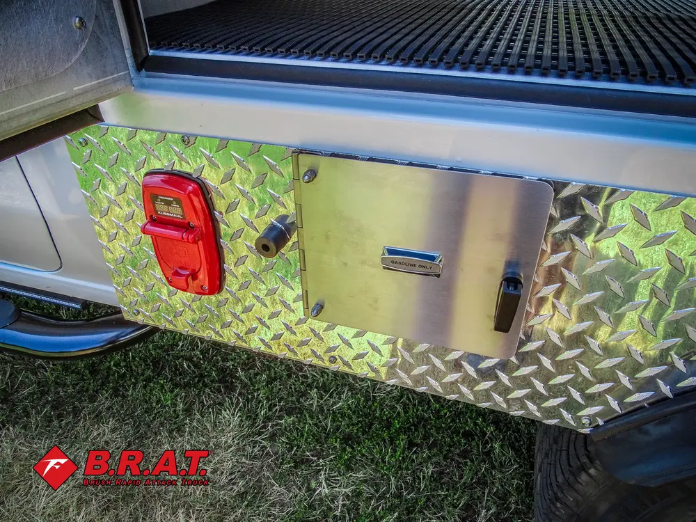 Exterior view of small fire truck showing cab, body compartments, and wheel/tire area.