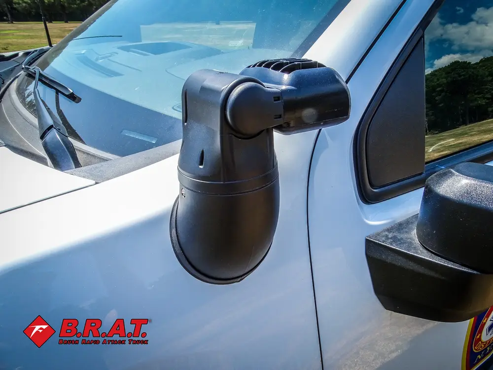 Exterior view of small fire truck showing cab, body compartments, and wheel/tire area.