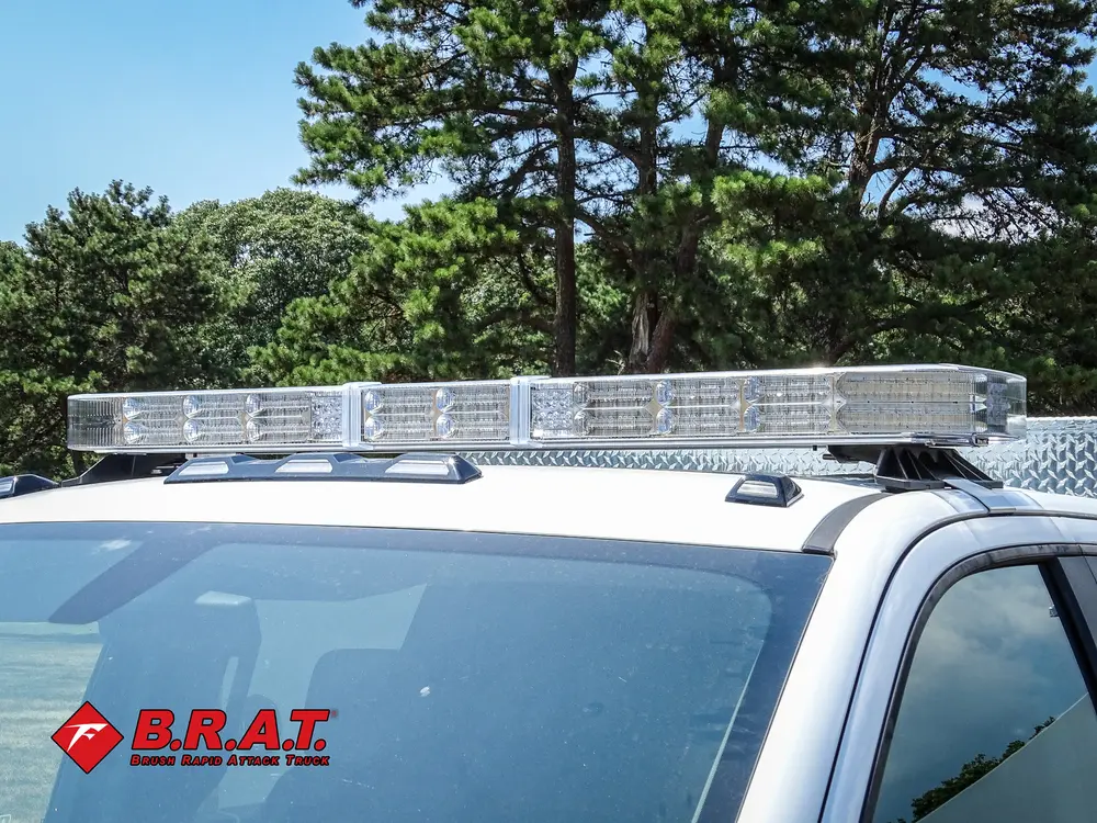 Exterior view of small fire truck showing cab, body compartments, and wheel/tire area.