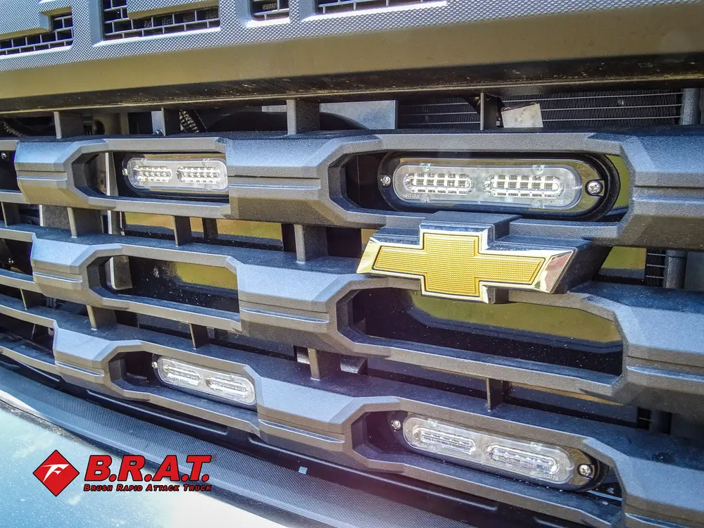 Exterior view of small fire truck showing cab, body compartments, and wheel/tire area.