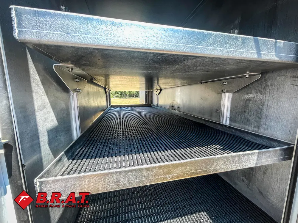 Exterior view of small fire truck showing cab, body compartments, and wheel/tire area.