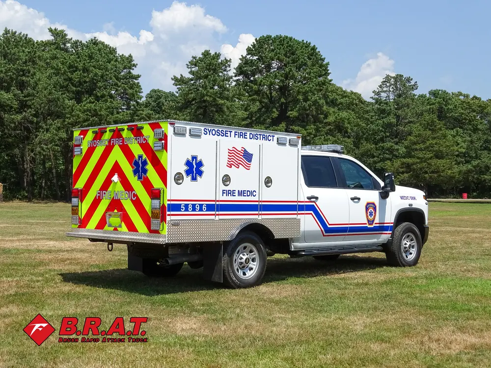 Exterior view of small fire truck showing cab, body compartments, and wheel/tire area.