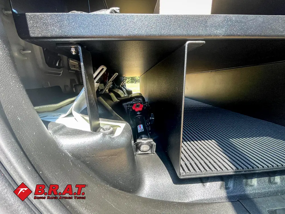 Exterior view of small fire truck showing cab, body compartments, and wheel/tire area.