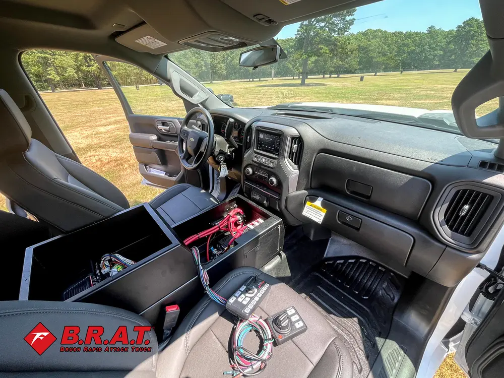 Exterior view of small fire truck showing cab, body compartments, and wheel/tire area.