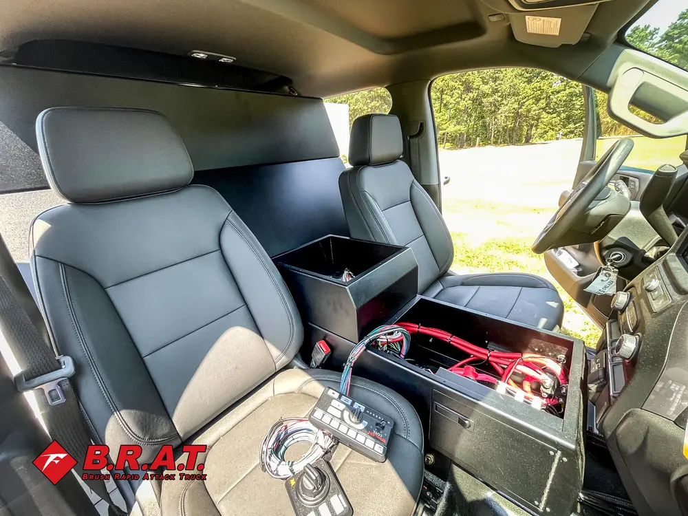 Exterior view of small fire truck showing cab, body compartments, and wheel/tire area.