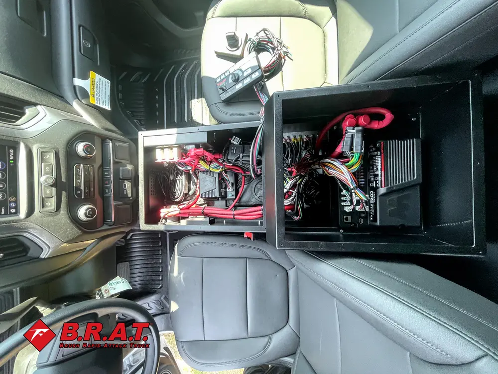 Exterior view of small fire truck showing cab, body compartments, and wheel/tire area.