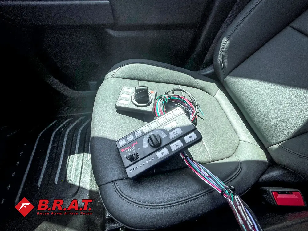 Exterior view of small fire truck showing cab, body compartments, and wheel/tire area.