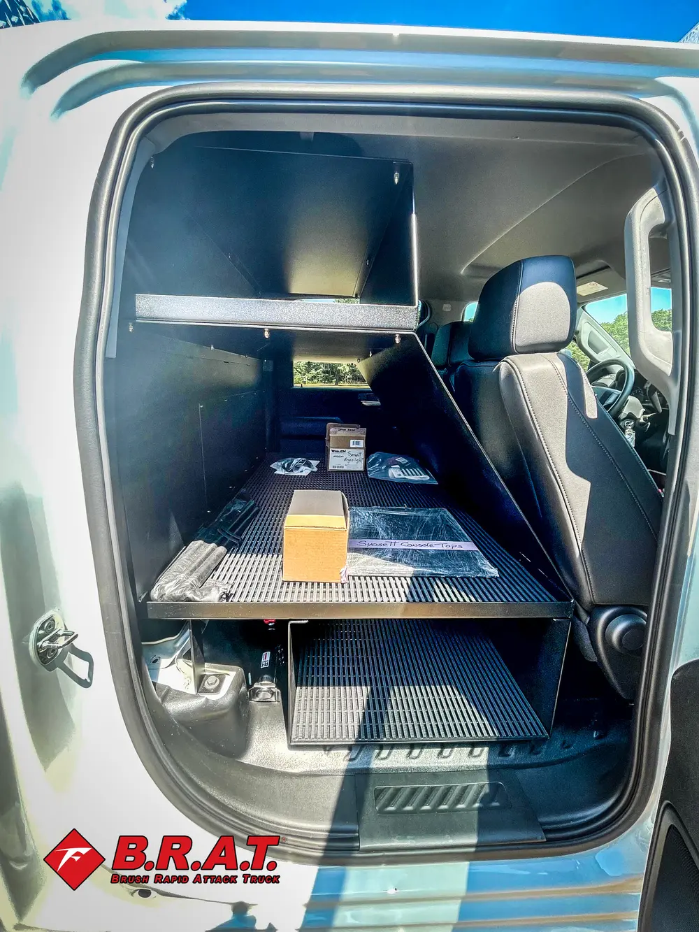 Exterior view of small fire truck showing cab, body compartments, and wheel/tire area.