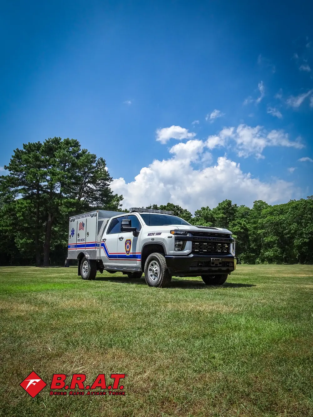 Exterior view of small fire truck showing cab, body compartments, and wheel/tire area.