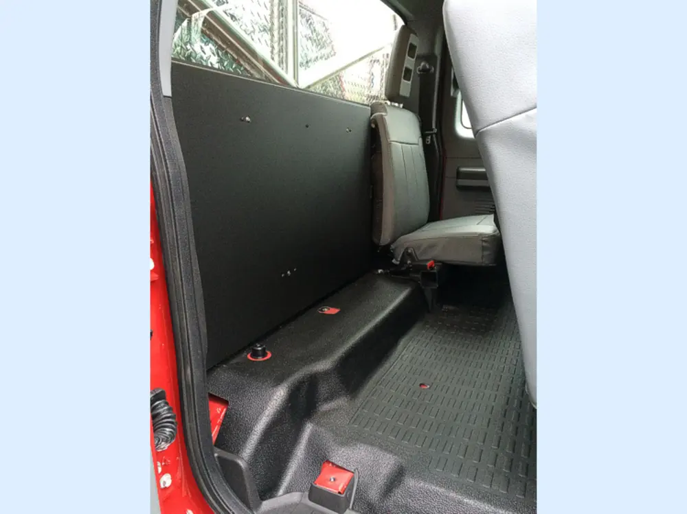 Exterior view of small fire truck showing cab, body compartments, and wheel/tire area.