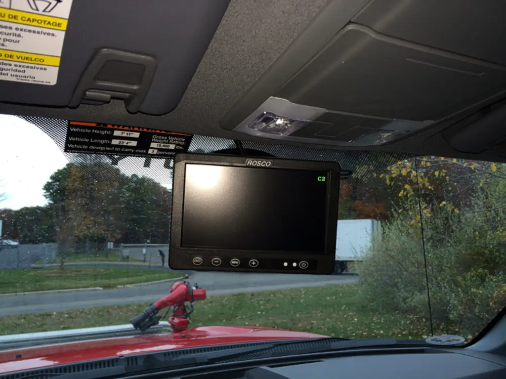 Exterior view of small fire truck showing cab, body compartments, and wheel/tire area.