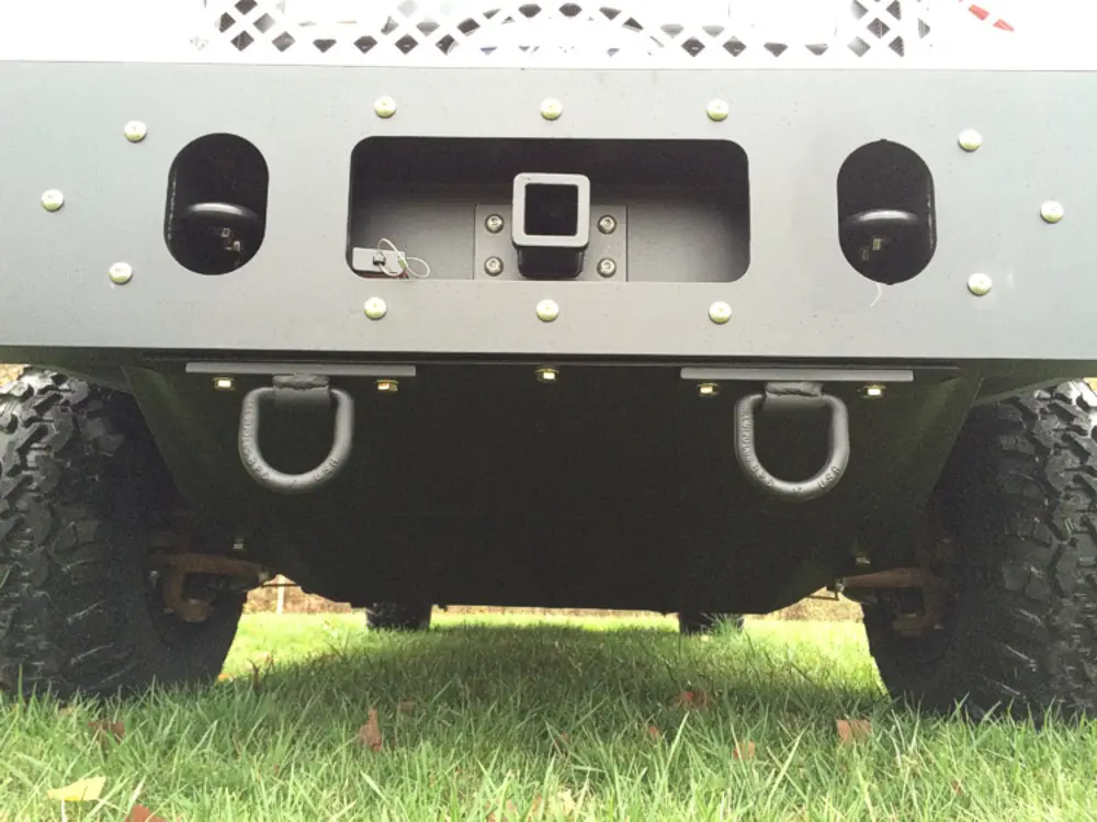 Exterior view of small fire truck showing cab, body compartments, and wheel/tire area.