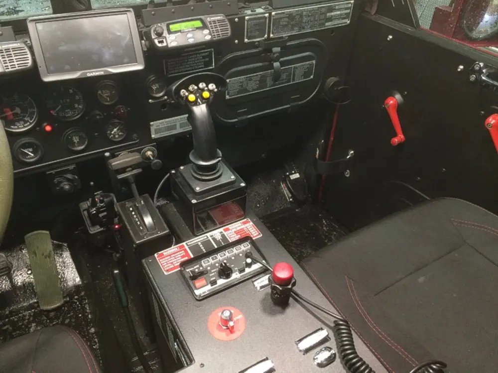 Exterior view of small fire truck showing cab, body compartments, and wheel/tire area.