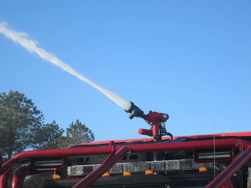 Exterior view of small fire truck showing cab, body compartments, and wheel/tire area.