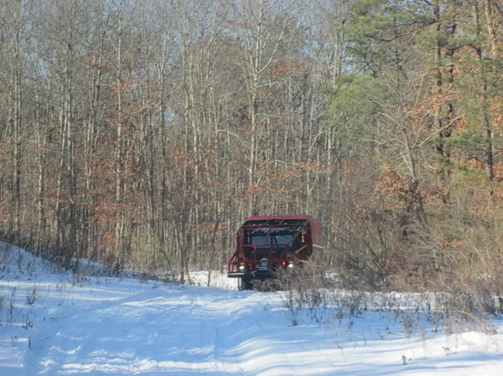 Exterior view of small fire truck showing cab, body compartments, and wheel/tire area.