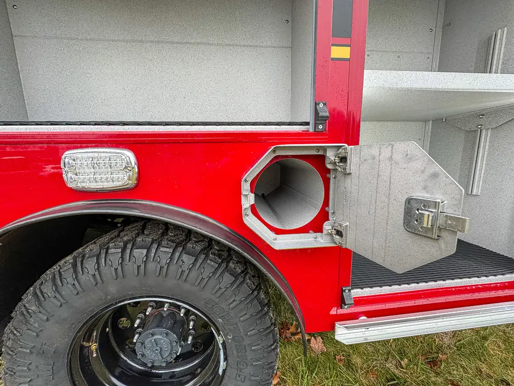 Lower side compartment close-up near wheel with intake fitting.