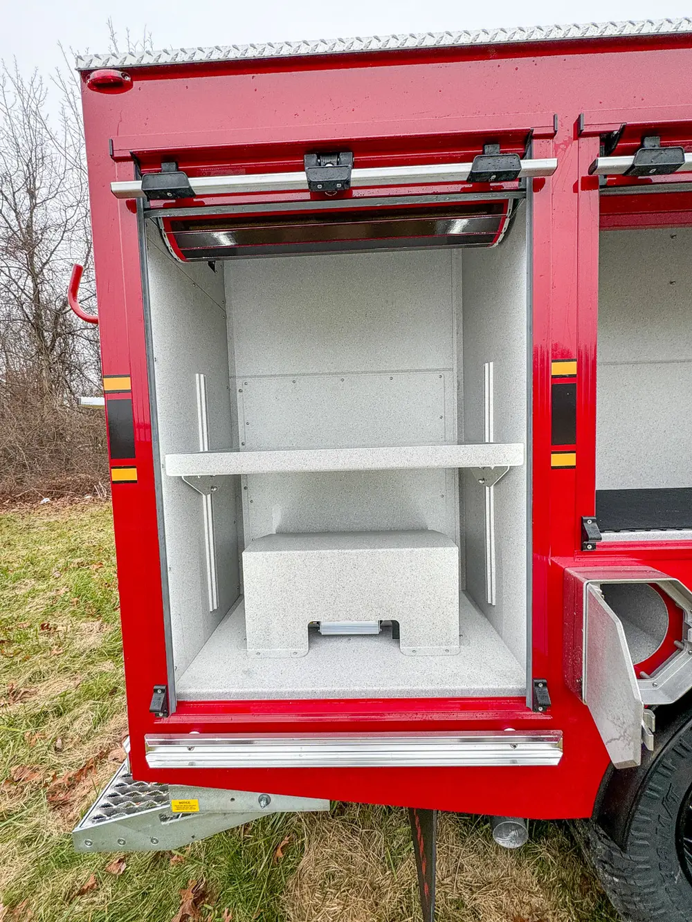 Narrow side compartment with two shelves and empty interior.