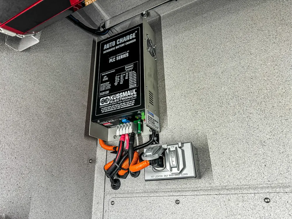 Side compartment wall with mounted battery charger and outlet box.