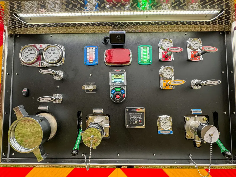 Rear pump panel close-up with gauges, valves, and labeled controls.