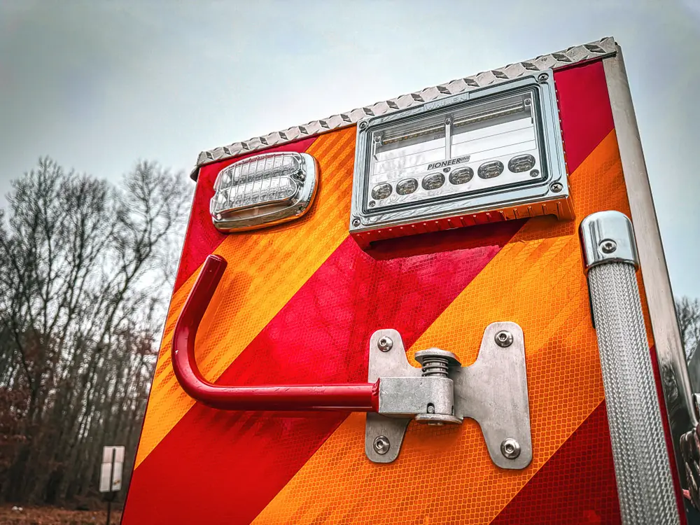 Rear corner close-up with taillight, connector, and mounting hardware.
