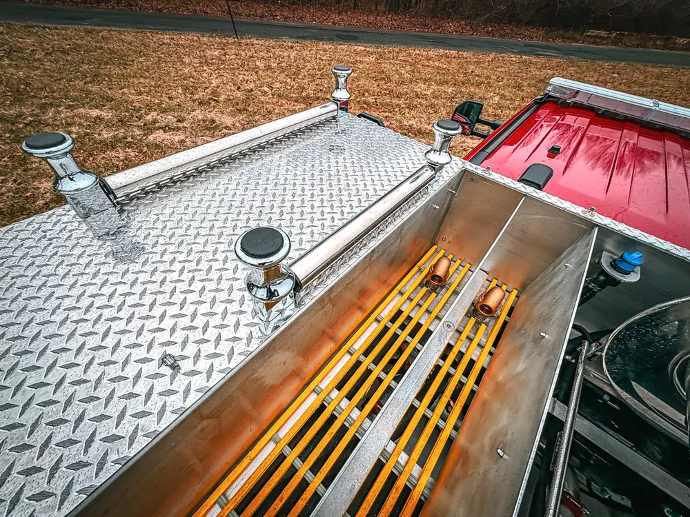 Upper deck side view with diamond-plate surface and grating channels.