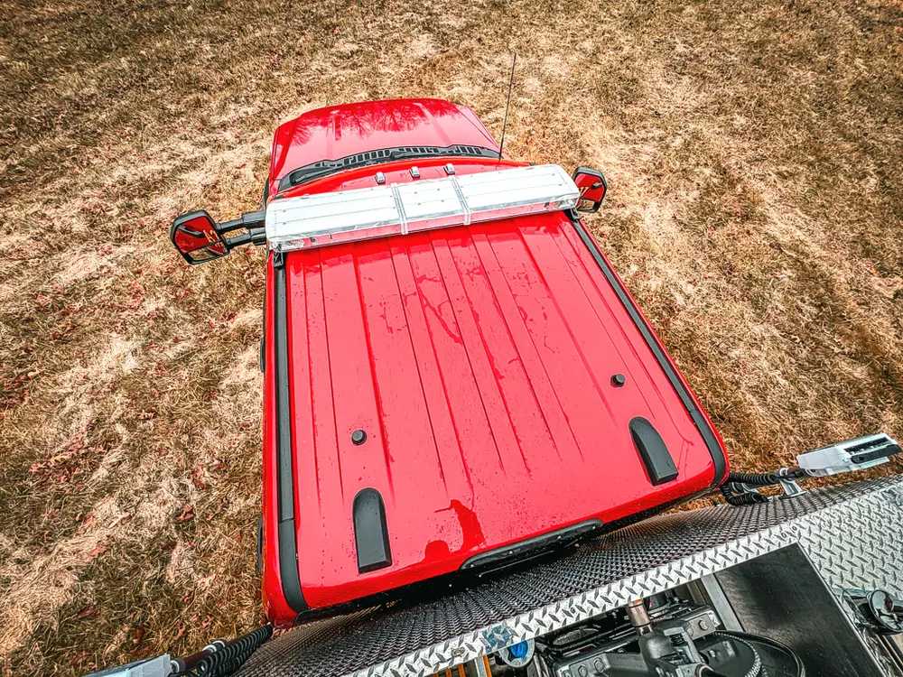 Top rear deck view with red hosebed cover and side rails.