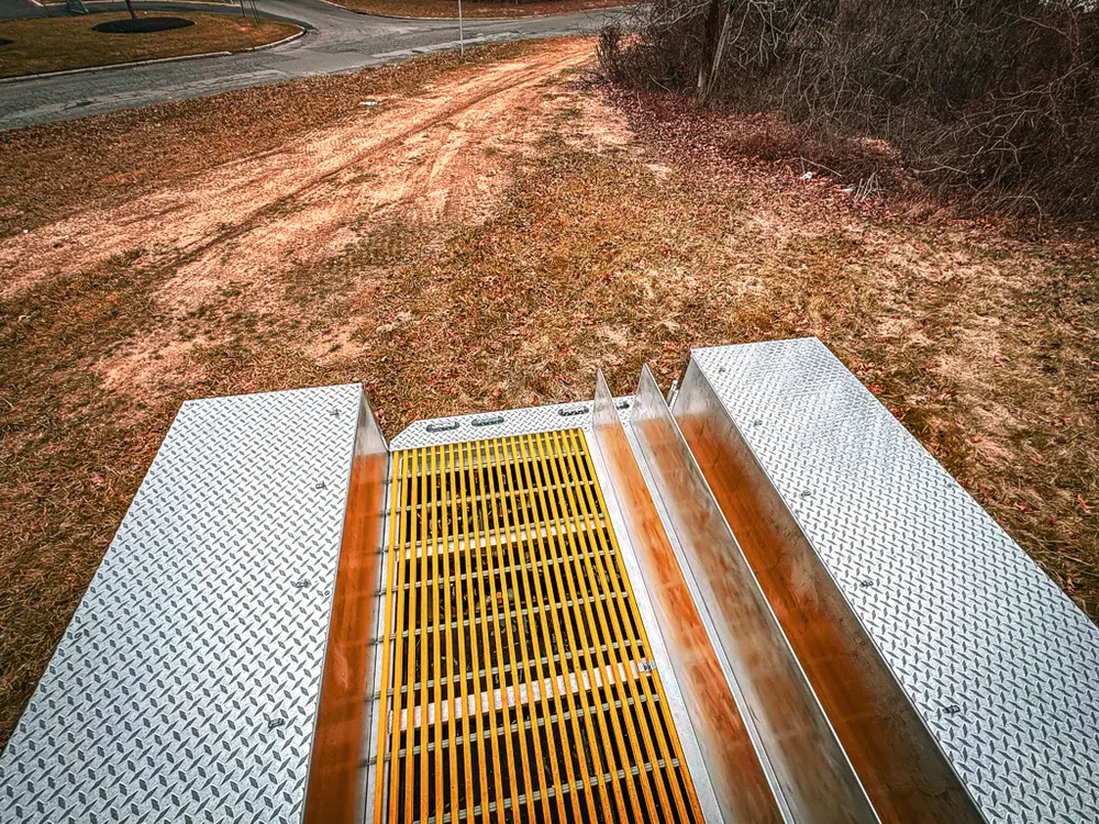 Top view down the yellow grated walkway toward center equipment bay.
