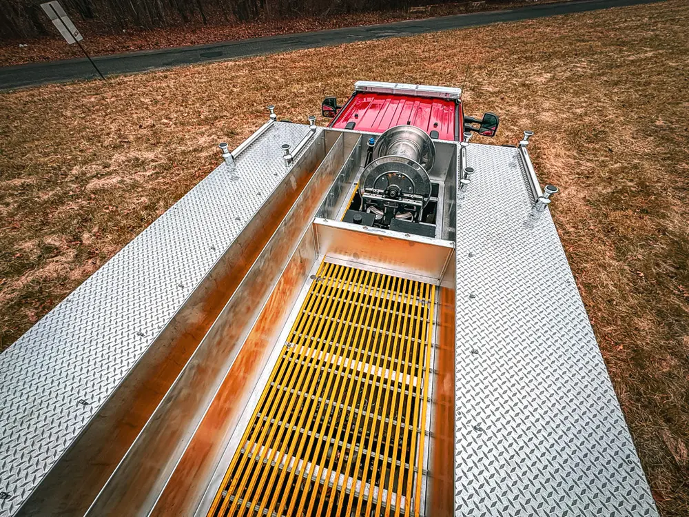 Top deck angle with grating, side rail, and center reel housing.