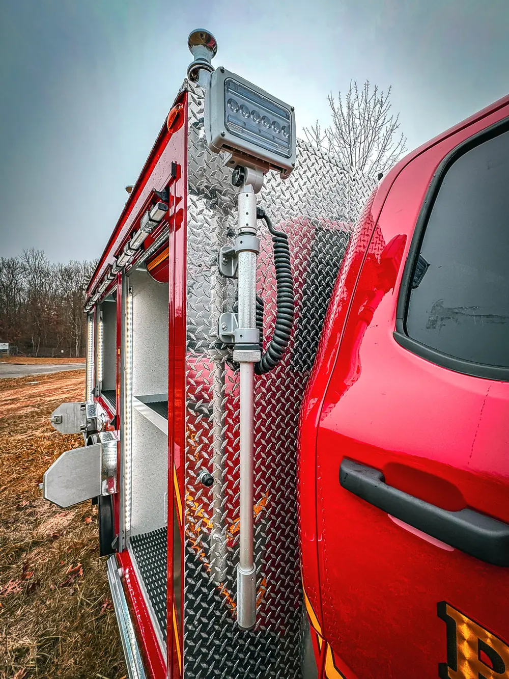 Rear upper body view with spare tire mount and diamond-plate panels.