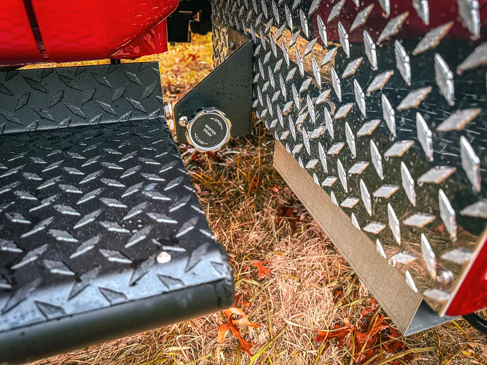 Diamond-plate side step close-up with key cylinder and trim.