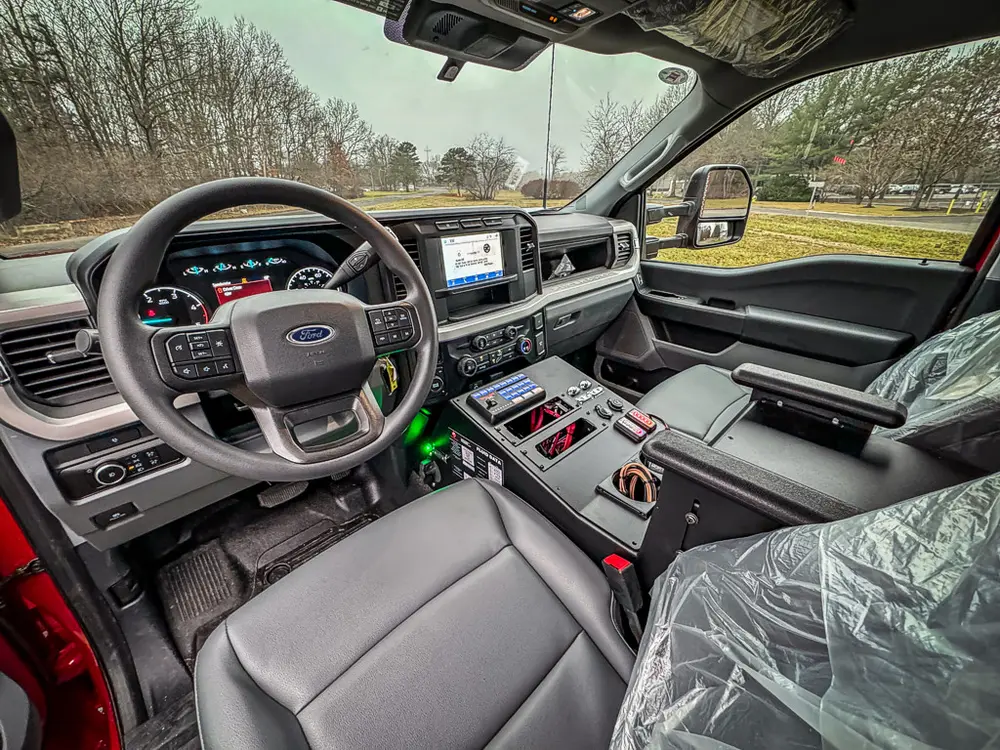 Front cabin interior view with steering wheel and center console.