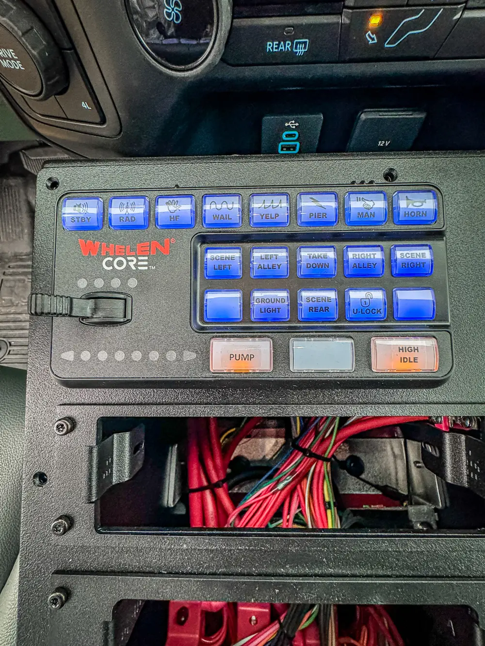 Close-up of Whelen control keypad with illuminated blue buttons.