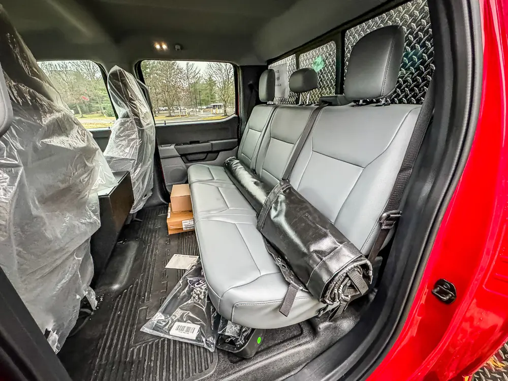 Rear passenger seating area with seats covered in protective plastic.