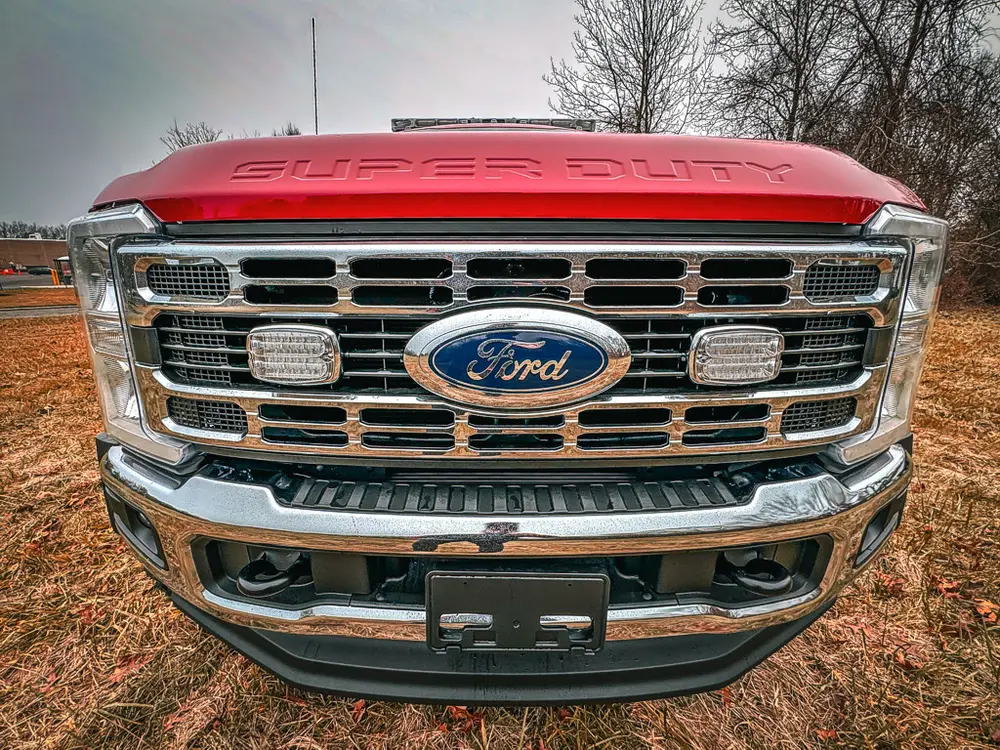 Front grille close-up with Ford emblem and emergency lights.