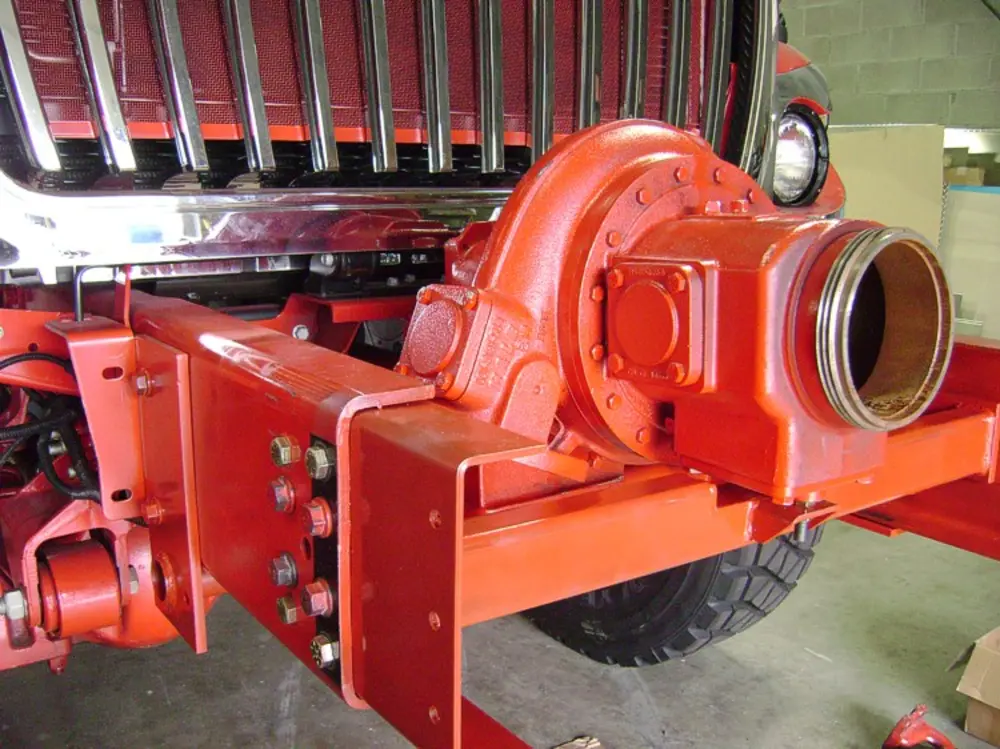 Exterior view of small fire truck showing cab, body compartments, and wheel/tire area.