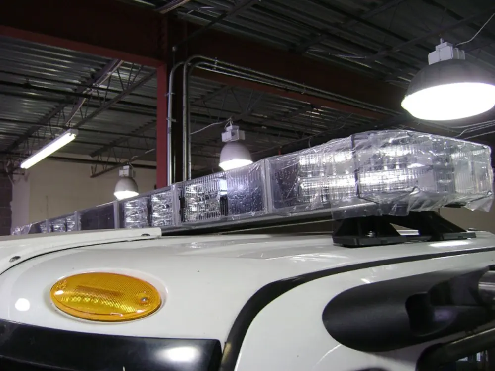 Exterior view of small fire truck showing cab, body compartments, and wheel/tire area.