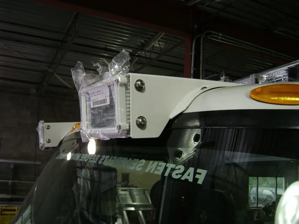 Exterior view of small fire truck showing cab, body compartments, and wheel/tire area.