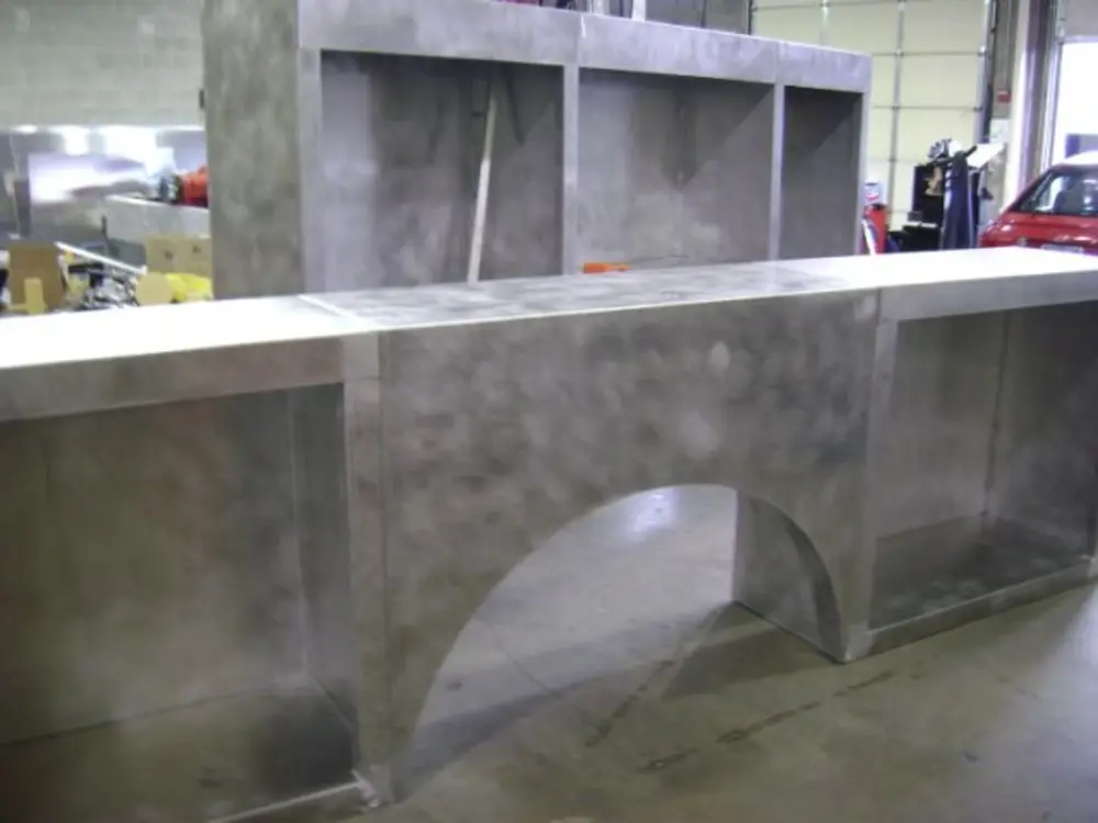 Exterior view of small fire truck showing cab, body compartments, and wheel/tire area.