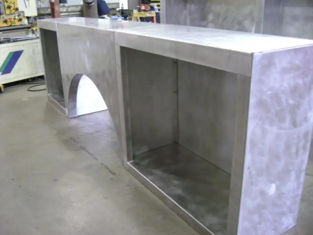 Exterior view of small fire truck showing cab, body compartments, and wheel/tire area.