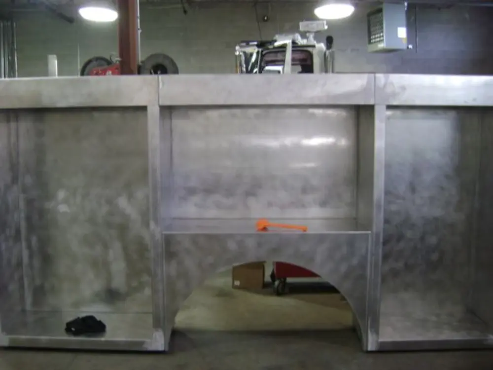 Exterior view of small fire truck showing cab, body compartments, and wheel/tire area.