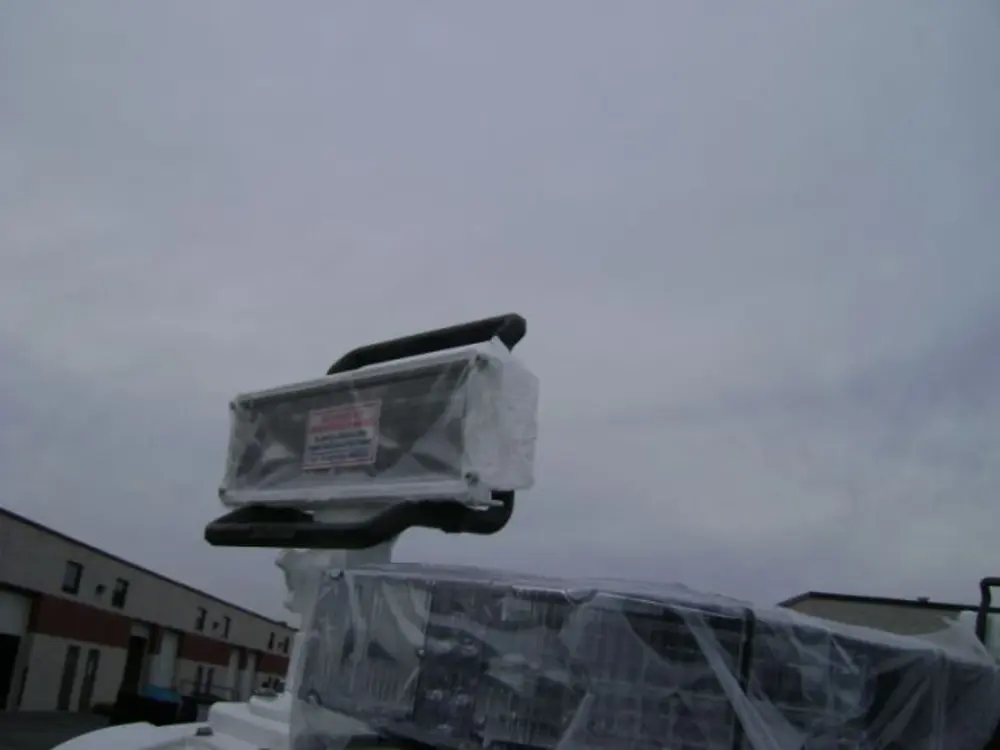 Exterior view of small fire truck showing cab, body compartments, and wheel/tire area.