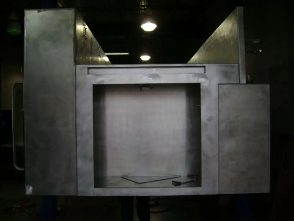 Exterior view of small fire truck showing cab, body compartments, and wheel/tire area.