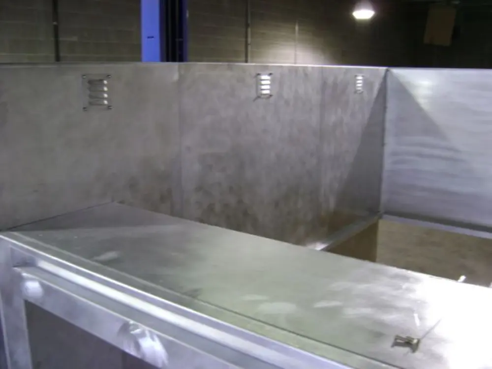 Exterior view of small fire truck showing cab, body compartments, and wheel/tire area.