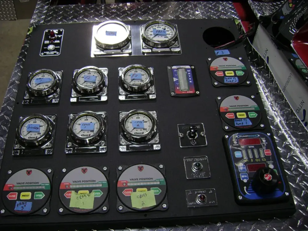 Exterior view of small fire truck showing cab, body compartments, and wheel/tire area.