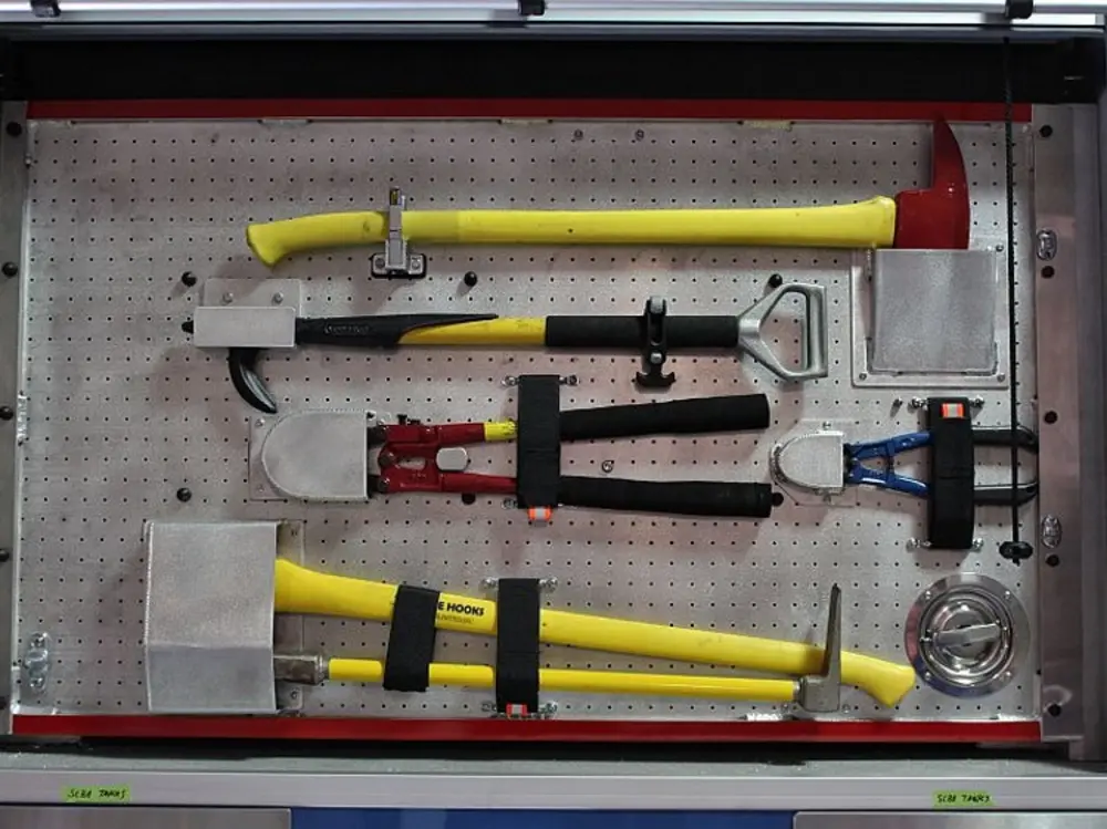 Exterior view of small fire truck showing cab, body compartments, and wheel/tire area.