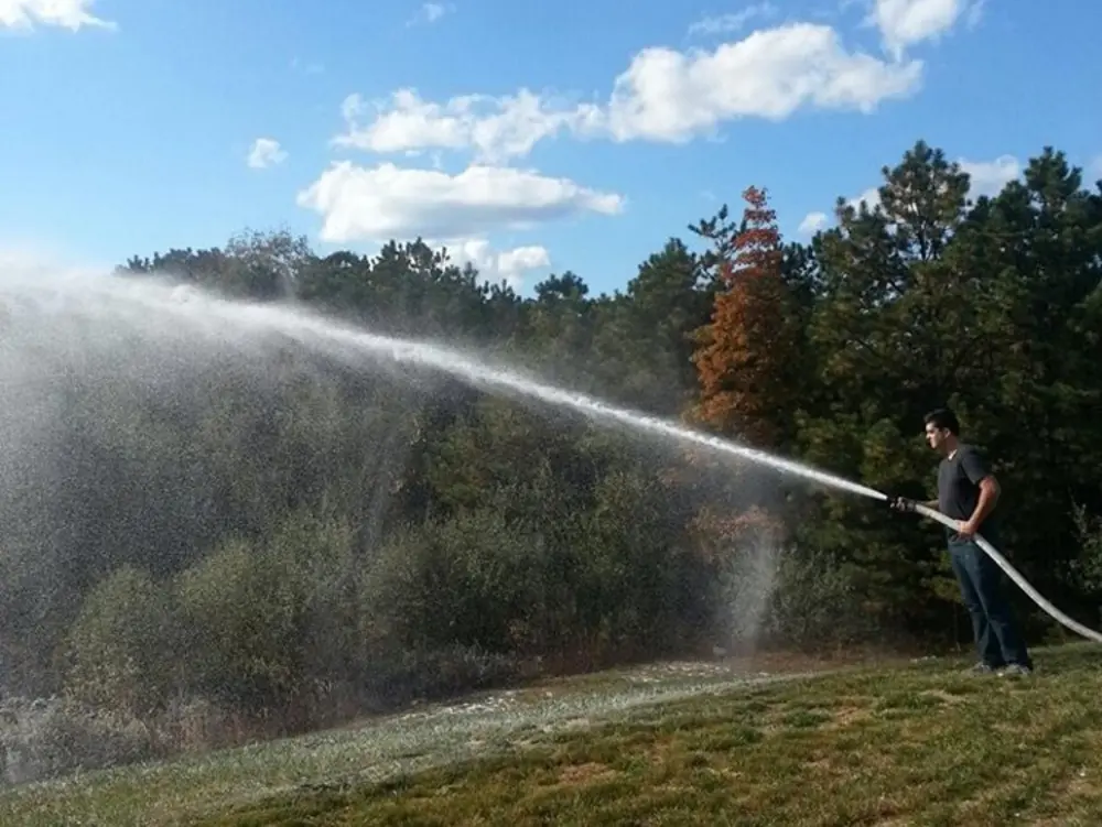 Exterior view of small fire truck showing cab, body compartments, and wheel/tire area.
